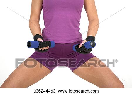Female exerciser squatting with hand weights View Large Photo Image Stock Image - Female exerciser squatting with hand weights. Fotosearch