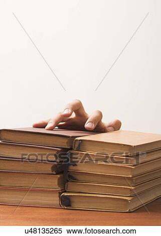 Stock Photography - Fingers on a stack of books. Fotosearch