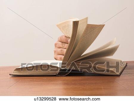 Stock Photo - Fingers turning pages in a book. Fotosearch