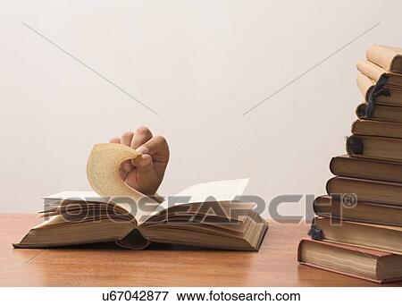 Stock Photo - Fingers turning the pages of a book. Fotosearch