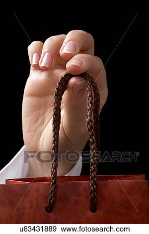 Stock Photo - Hand holding handle to bag. Fotosearch