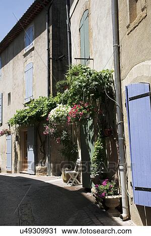 Stock Image - Hanging flowers on old buildings. Fotosearch