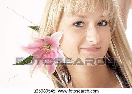 Stock Photography - Head shot of woman with lily. Fotosearch
