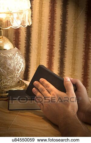 Stock Photo - Human hands holding a Bible. Fotosearch