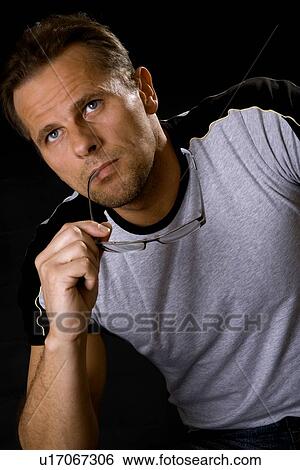 Man holding eye glasses View Large Photo Image Stock Photograph - Man holding eye glasses. Fotosearch