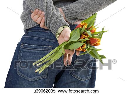 Stock Photography - Man holding flowers behind his back. Fotosearch