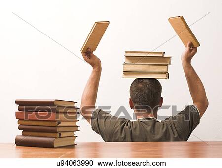 Stock Image - Man stacking books on his head. Fotosearch