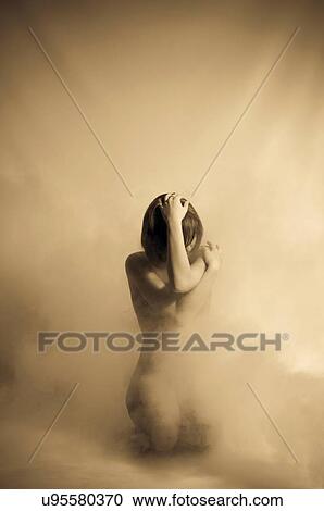 Stock Image - Sepia tone woman in fog. Fotosearch