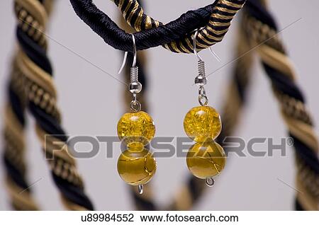 Two earrings hanging on a necklace View Large Photo Image Stock Image - Two earrings hanging on a necklace. Fotosearch