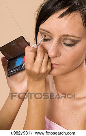 Stock Photo - Woman applying eye shadow. Fotosearch
