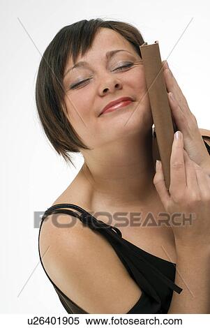 Stock Photography - Woman holding book to face. Fotosearch