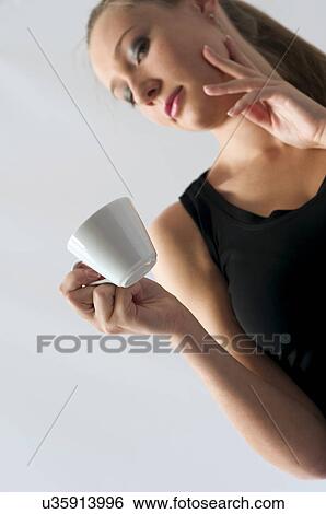 Stock Photograph - Woman holding coffee cup. Fotosearch
