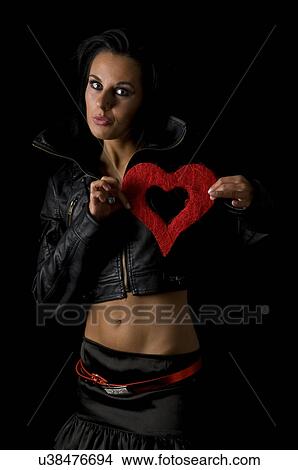 Woman in leather holding a red heart View Large Photo Image Picture - Woman in leather holding a red heart. Fotosearch