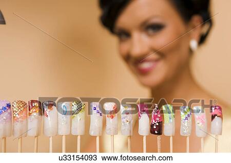 Stock Image - Woman with artificial nail display. Fotosearch