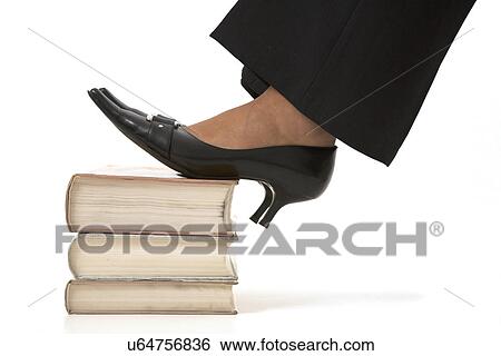 Womans feet resting on a stack of books View Large Photo Image Stock Photograph - Womans feet resting on a stack of books. Fotosearch