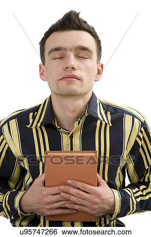 Young man holding a book View Large Photo Image Stock Photograph - Young man holding a book. Fotosearch