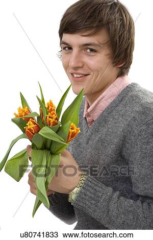Stock Image - Young man holding a bunch of flowers. Fotosearch