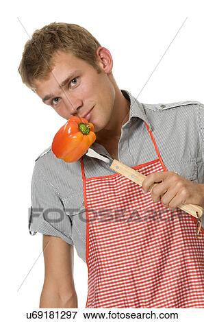 Young man holding fork with orange pepper View Large Photo Image Stock Photo - Young man holding fork with orange pepper. Fotosearch