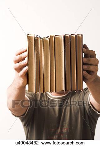 Young man holding out books View Large Photo Image Stock Image - Young man holding out books. Fotosearch