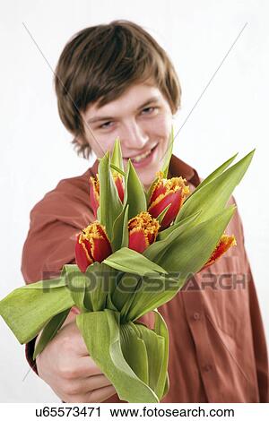 Stock Image - Young man with a bunch of tulips. Fotosearch