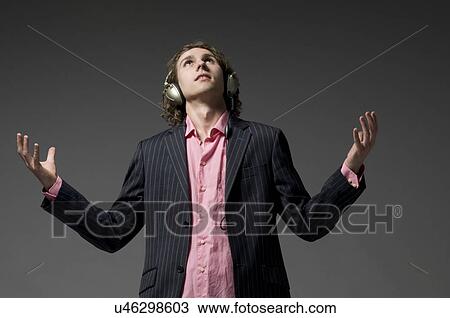 Young man with headphones looking up View Large Photo Image Stock Image - Young man with headphones looking up. Fotosearch