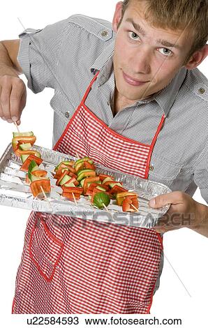 Young man with shish kabobs View Large Photo Image Stock Image - Young man with shish kabobs. Fotosearch