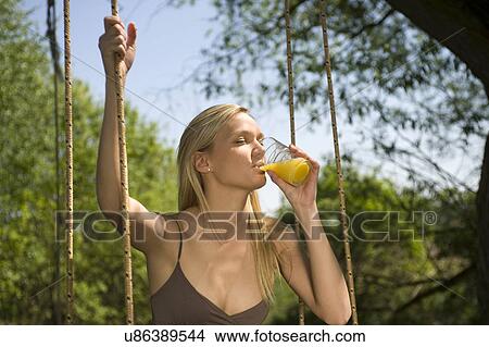 Picture - Young woman drinking orange juice. Fotosearch