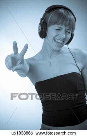 Stock Photography - Young woman listening to headphones. Fotosearch
