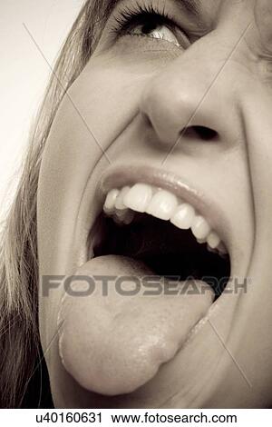 Young woman sticking tongue out View Large Photo Image Stock Image - Young woman sticking tongue out. Fotosearch