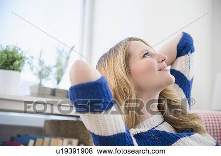 Stock Photo - Blond woman daydreaming at home. Fotosearch