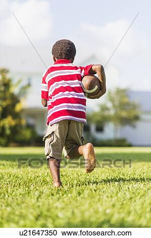 boy (6-7) playing football View Large Photo Image Stock Image - boy (6-7) playing football. Fotosearch