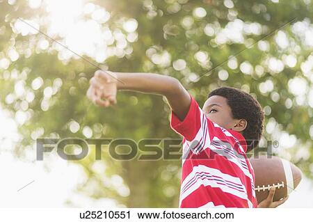 boy (6-7) playing football View Large Photo Image Stock Image - boy (6-7) playing football. Fotosearch