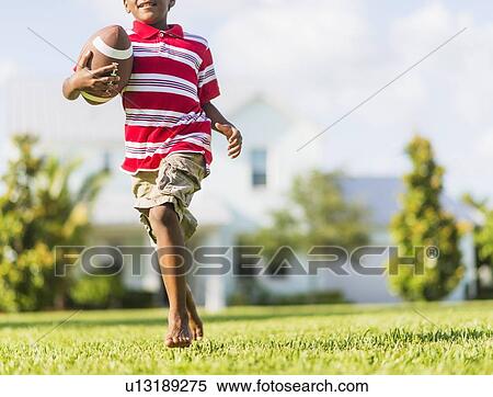 boy (6-7) playing football View Large Photo Image Stock Photography - boy (6-7) playing football. Fotosearch