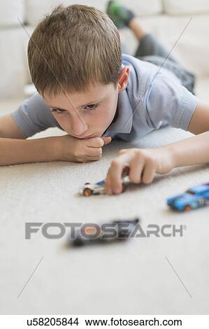 boy (8-9) playing with toy cars View Large Photo Image Picture - boy (8-9) playing with toy cars. Fotosearch