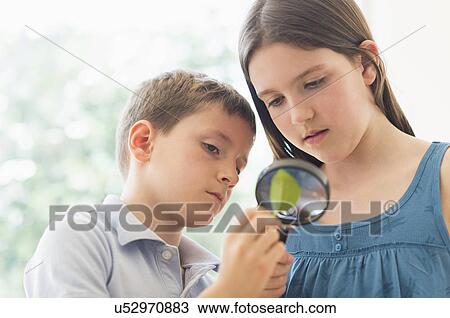 Boy and girl (8-9, 10-11) looking through magnifying glass View Large Photo Image Stock Image - Boy and girl (8-9, 10-11) looking through magnifying glass. Fotosearch