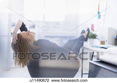 Business woman relaxing in office View Large Photo Image Stock Image - Business woman relaxing in office. Fotosearch