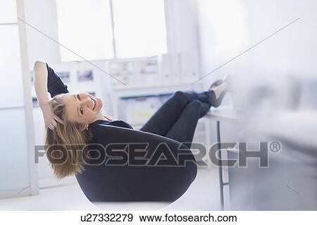Business woman relaxing in office View Large Photo Image Stock Photo - Business woman relaxing in office. Fotosearch