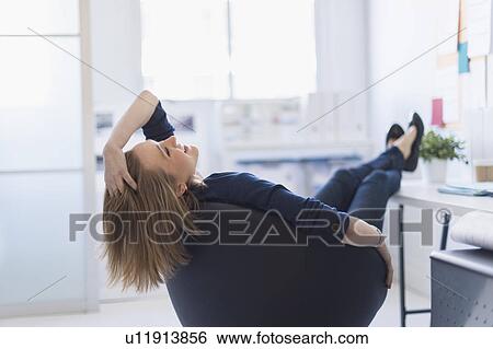 Business woman relaxing in office View Large Photo Image Stock Photograph - Business woman relaxing in office. Fotosearch