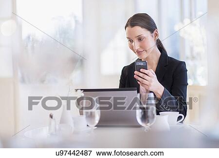 Stock Photo - Businesswoman working on laptop in restaurant. Fotosearch