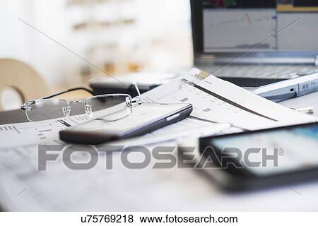 Close up of glasses on paperwork View Large Photo Image Stock Photo - Close up of glasses on paperwork. Fotosearch