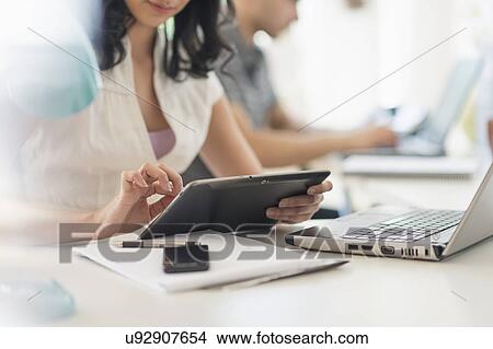 Picture - Close up of young woman and man working in office. Fotosearch