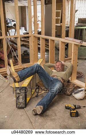 Stock Photo - Construction worker falling of ladder inside new structure. Fotosearch