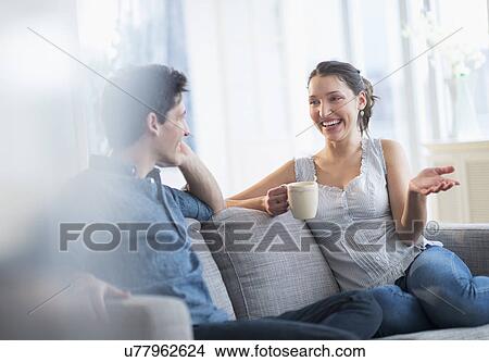 Picture - Couple relaxing on sofa. Fotosearch