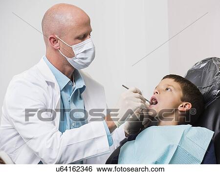 Stock Photograph - Dentist checking mouth of patient( 12-13). Fotosearch