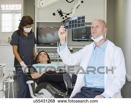 Stock Photo - Dentist looking at x-ray. Fotosearch