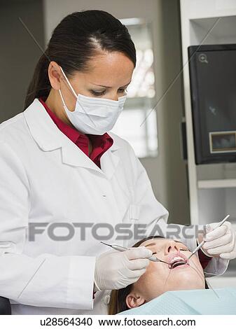 Stock Image - Dentist operation on patient. Fotosearch