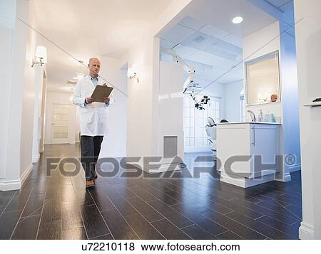 Doctor walking through corridor of clinic View Large Photo Image Stock Photo - Doctor walking through corridor of clinic. Fotosearch