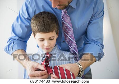 Stock Image - Father adjusting son's(8-9) tie . Fotosearch