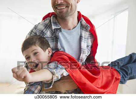 Stock Photography - Father and son (8-9) acting as super heroes. Fotosearch