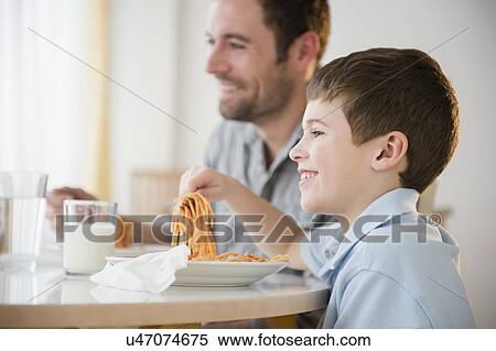 Father and son (8-9) eating spaghetti View Large Photo Image Stock Photography - Father and son (8-9) eating spaghetti . Fotosearch